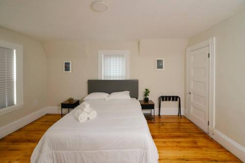 a bedroom with a large white bed with two pillows at Boston Historical Urban Oasis in Boston