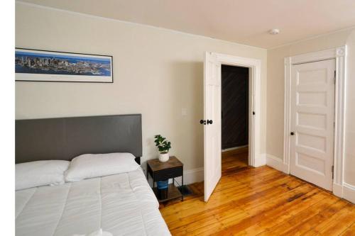 a bedroom with a bed and a table and a door at Boston Historical Urban Oasis in Boston