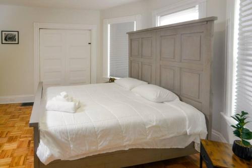a bedroom with a large white bed with two pillows at Boston Historical Urban Oasis in Boston