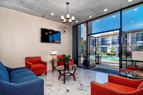 a waiting room with red chairs and a table at Quality Inn & Suites South San Jose - Morgan Hill in Morgan Hill
