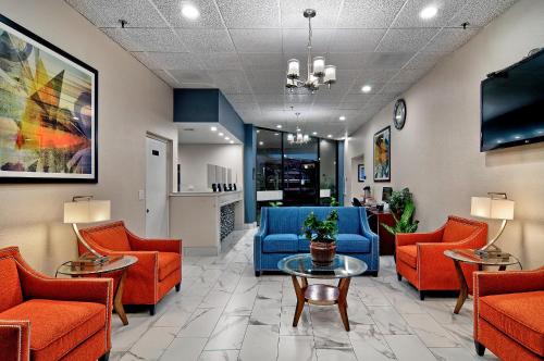 a waiting room with orange chairs and a blue couch at Quality Inn & Suites South San Jose - Morgan Hill in Morgan Hill
