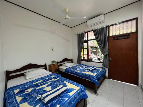a bedroom with two beds and a window at Bagus Homestay in Padangbai