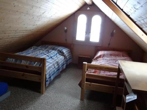 a attic bedroom with two beds and a window at Hof Bommes in Gais