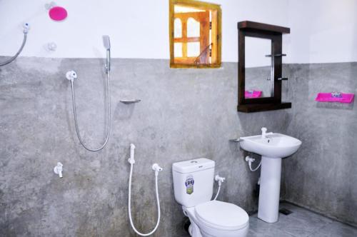 a bathroom with a shower and a toilet and a sink at Impress Holiday Home in Anuradhapura