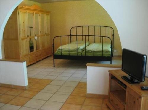 1 dormitorio con 1 cama y TV en una habitación en Wohnung in Schönwald Im Schwarzwald mit Garten und Terrasse, en Schönwald