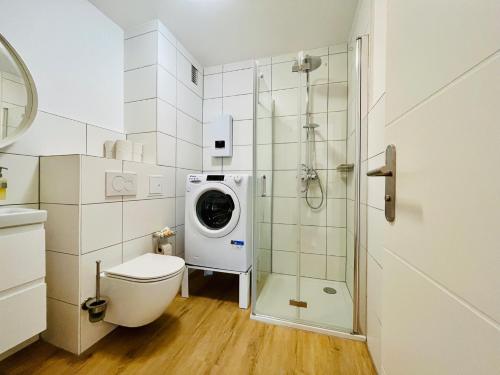 a bathroom with a toilet and a washing machine at Emilbnb in der Reiherstraße in Monheim