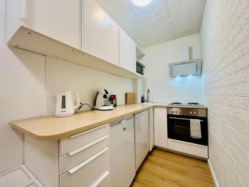 a kitchen with white cabinets and a wooden counter top at Emilbnb in der Reiherstraße in Monheim