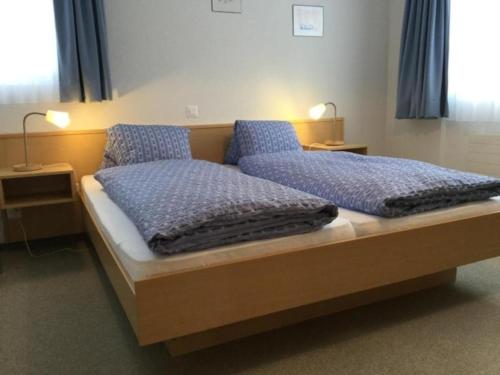 Un dormitorio con una cama con almohadas azules. en Topwohnung für 2 - 3 Personen mit einem getrennten Schlafzimmer en Saas-Almagell
