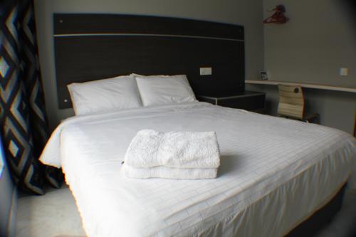 a bedroom with a bed with a white towel on it at Bercham Vacation House in Ipoh