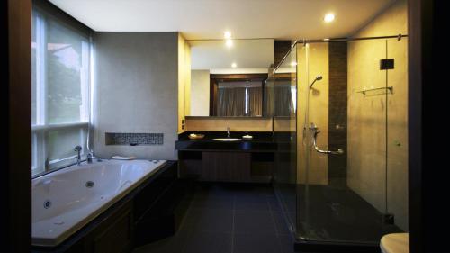 a bathroom with a tub and a shower and a sink at Karon Suite Apartment in Karon Beach