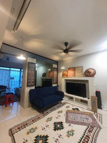 a living room with a blue couch and a tv at Studio near KLCC and LRT with superb view in Kuala Lumpur