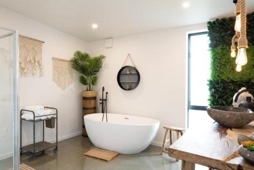 a bathroom with a large white tub and a sink at NOMAC No8, Luxury holiday home, Twizel in Twizel