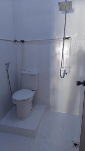 a white bathroom with a toilet and a shower at My Guest House She 