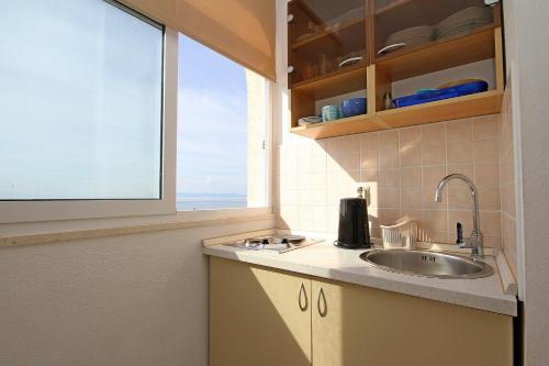 cocina con fregadero y ventana en Apartments Adrion, en Drasnice