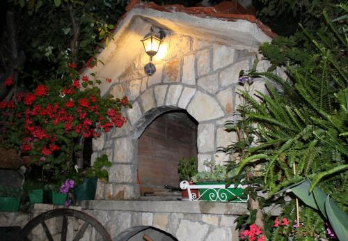 a small stone building with flowers and a light at Apartments Adrion in Drasnice