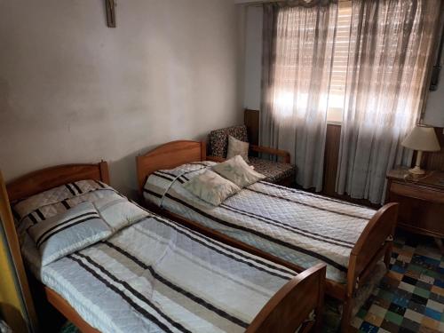 2 camas individuales en una habitación con ventana en Monoambiente sencillo a 2 de la peatonal y 2 del mar en Mar del Plata