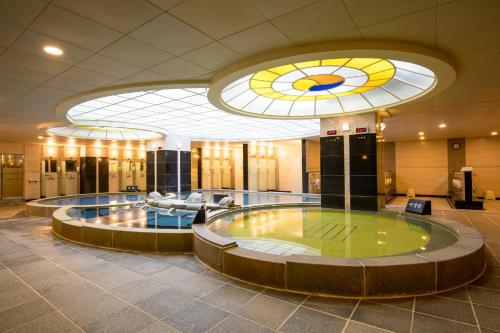 a large lobby with a large pool in the middle of a building at Sono Belle Jeju in Jeju