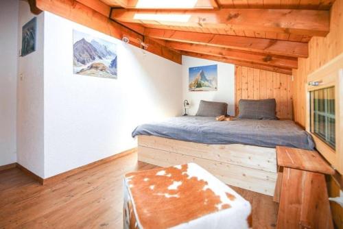 1 dormitorio con 1 cama en una cabaña de madera en 3 12 Zimmer Wohnung, en Axalp