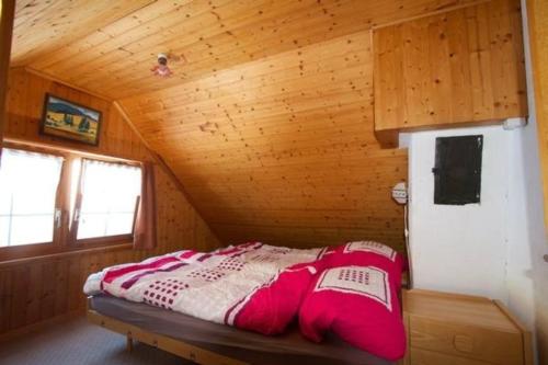 Łóżko w domku z drewnianym sufitem w obiekcie Bauernhof Hasenbüel w mieście Sankt Peterzell