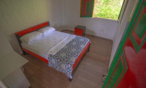 a small bedroom with a bed and a window at Hotel Terra Belén in Belén de Umbría