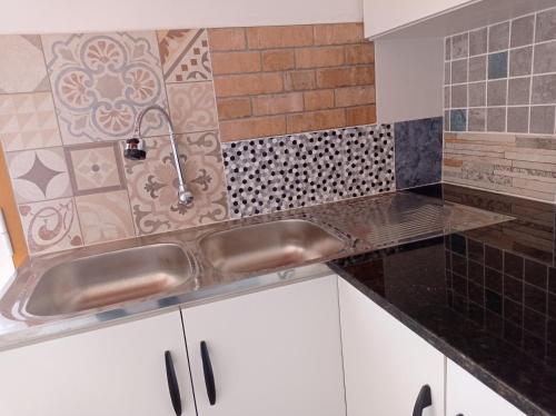 cocina con fregadero y pared de azulejos en Casa de la Amistad, en Areguá