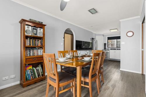 a dining room with a wooden table and chairs at Sea Eagle by Experience Jervis Bay in St Georges Basin
