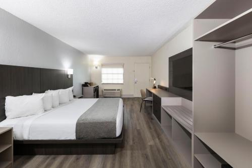 a hotel room with a bed and a desk at Avanti International Resort in Orlando
