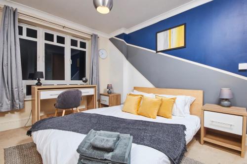 a bedroom with a bed and a blue wall at Free Parking-Central-Contractors-Leisure in Coventry