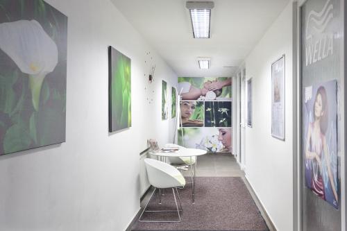 korytarz ze stołem i krzesłami oraz obrazami na ścianach w obiekcie Wellness Hotel ABÁCIE w Nowym Jiczynie