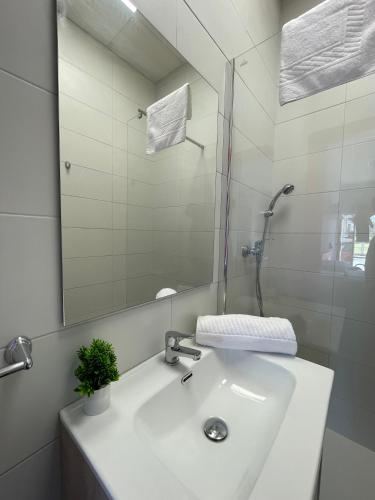 a white bathroom with a sink and a mirror at Hostel & Rooms O Albergue da Meiga in Padrón