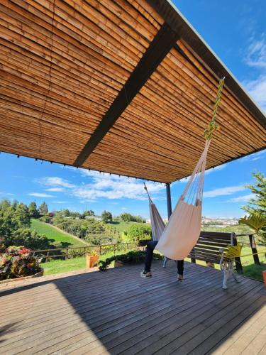 a woman sitting on a deck with two hammocks at San José de las bromelias in Marinilla