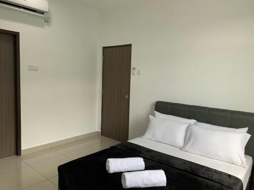 a bedroom with a bed with two towels on it at Desaru Utama Apartment with Swimming Pool View, Karaoke, FREE WIFI, Netflix, near to Car Park in Desaru