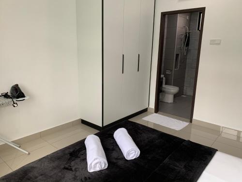 two white towels sitting on the floor of a bathroom at Desaru Utama Apartment with Swimming Pool View, Karaoke, FREE WIFI, Netflix, near to Car Park in Desaru