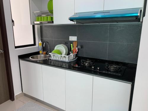 a kitchen counter with a sink and a stove at Desaru Utama Apartment with Swimming Pool View, Karaoke, FREE WIFI, Netflix, near to Car Park in Desaru