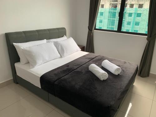um quarto com uma cama com duas almofadas em Desaru Utama Apartment with Swimming Pool View, Karaoke, FREE WIFI, Netflix, near to Car Park em Desaru