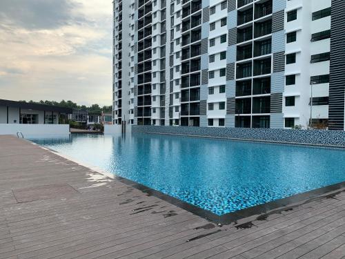 a large swimming pool in front of two tall buildings at Desaru Utama Apartment with Swimming Pool View, Karaoke, FREE WIFI, Netflix, near to Car Park in Desaru