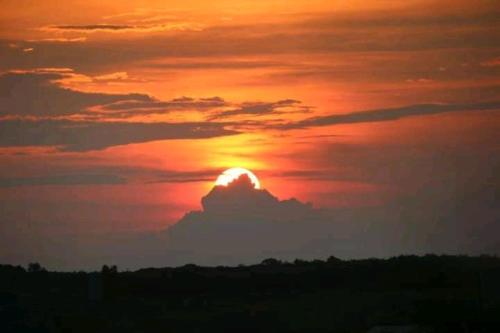 a sunset with the sun hiding behind a cloud at Quiet Garden View Lodge&Trekking in Banlung