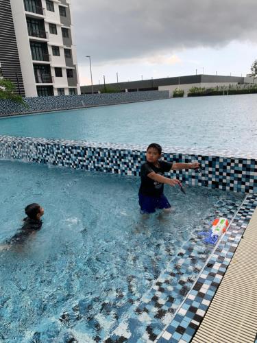 two young boys playing in a swimming pool at Desaru Utama Apartment with Swimming Pool View, Karaoke, FREE WIFI, Netflix, near to Car Park in Desaru