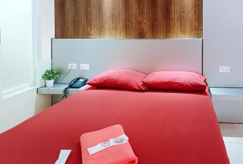 a red bed with two red pillows on it at Hakysia Hotel 
