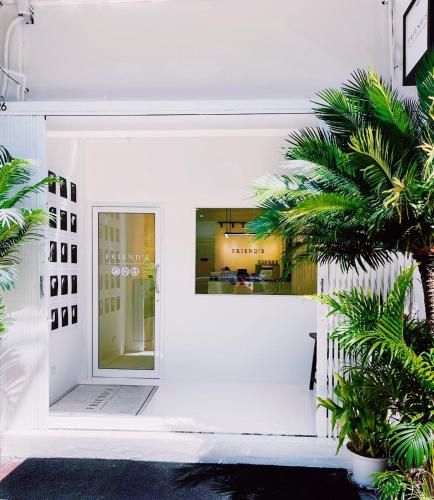 ein weißes Gebäude mit einem Fenster und Palmen in der Unterkunft Modern Minimalism - Mandarin Palm Penthouse in Bangkok