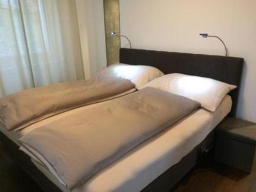 2 łóżka pojedyncze w pokoju z oknem w obiekcie Chavallera Casa Torri w Sankt Moritz