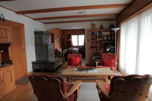 sala de estar con chimenea, mesa y sillas en Chalet Mon Refuge, en Laax