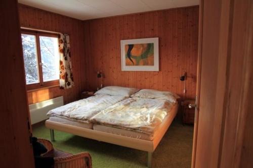 a bedroom with a bed in the corner of a room at Chalet Mon Refuge in Laax