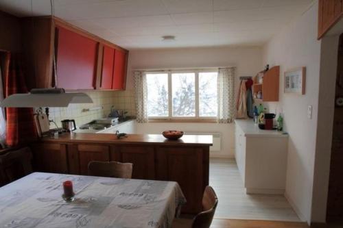 een keuken met rode kasten en een tafel erin bij Chalet Mon Refuge in Laax