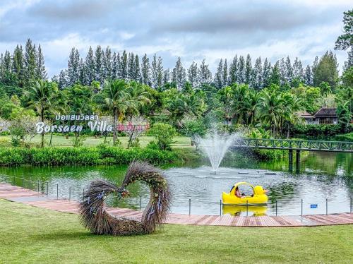 a pond with a yellow raft in a park at Bor Saen Pool Villa in Bor Saen