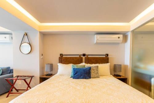 a bedroom with a large bed with blue pillows at Beachfront & free daily breakfast & 600MB 7010 Wifi by Moikkarentals in Puerto Vallarta