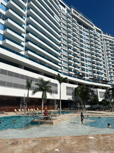 a large building with people in a swimming pool with a large building at APARTAMENTO CON VISTA AL MAR, RESERVA Del MAR 1637 in Gaira