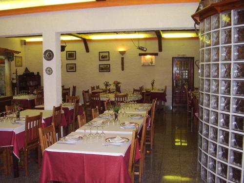 a dining room with tables and chairs with red table cloth at Residencial Morgado in Almeida