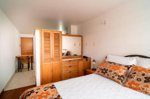 a bedroom with a bed and a wooden cabinet at 100 Wonderful House in Bogotá