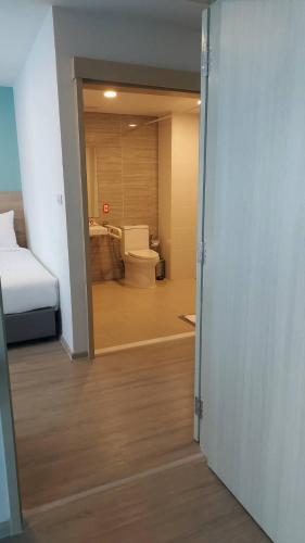 a bathroom with a bed and a toilet in a room at Wellness Stay & Hotel Sukhumvit 107 in Bangna